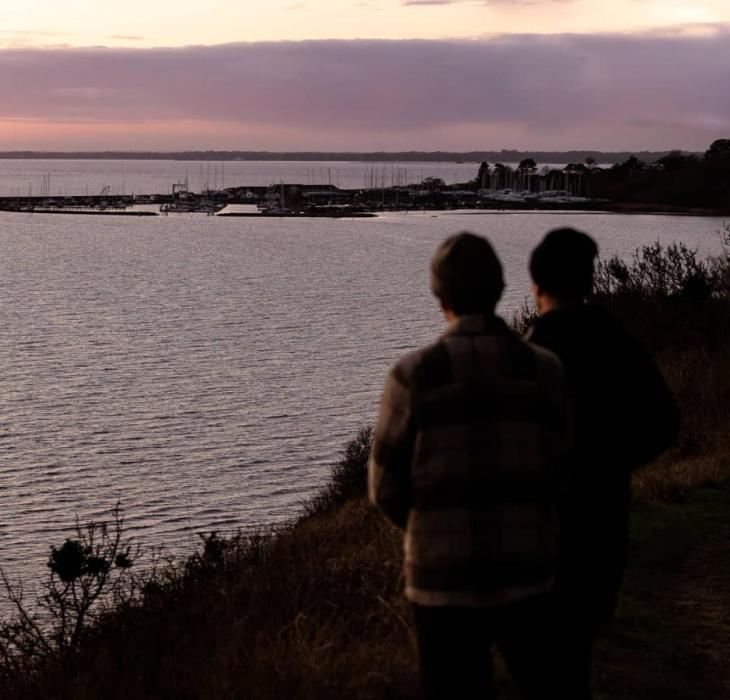 Udsigt fra Store Karlsminde udover havnen i Lynæs i solnedgangen