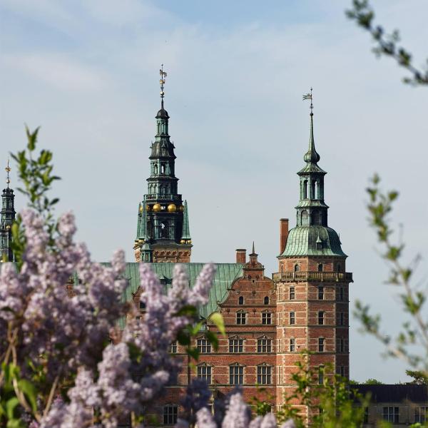 Frederiksborg Slot i forårssolen med syrener der blomstrer