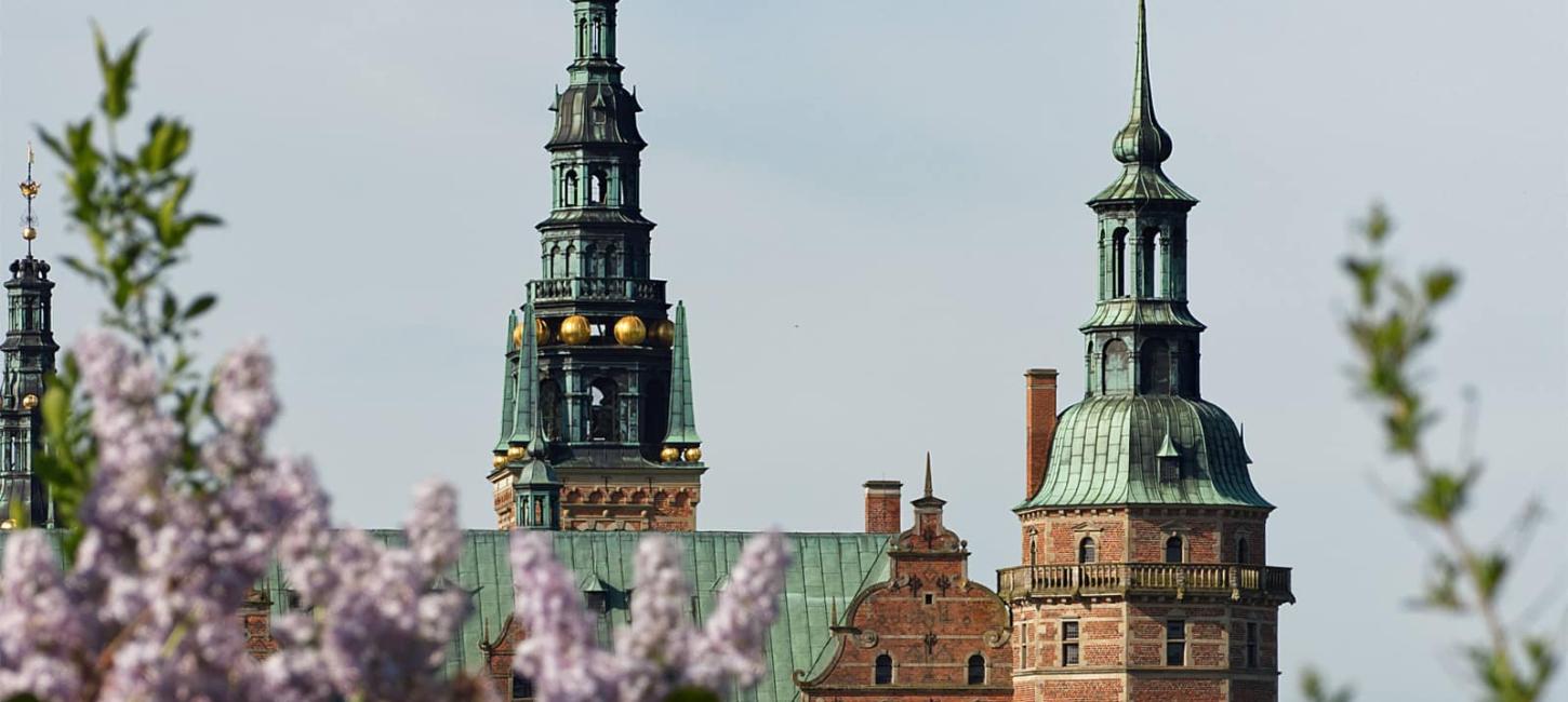 Frederiksborg Slot i forårssolen med syrener der blomstrer