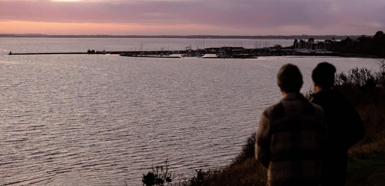 Udsigt fra Store Karlsminde udover havnen i Lynæs i solnedgangen