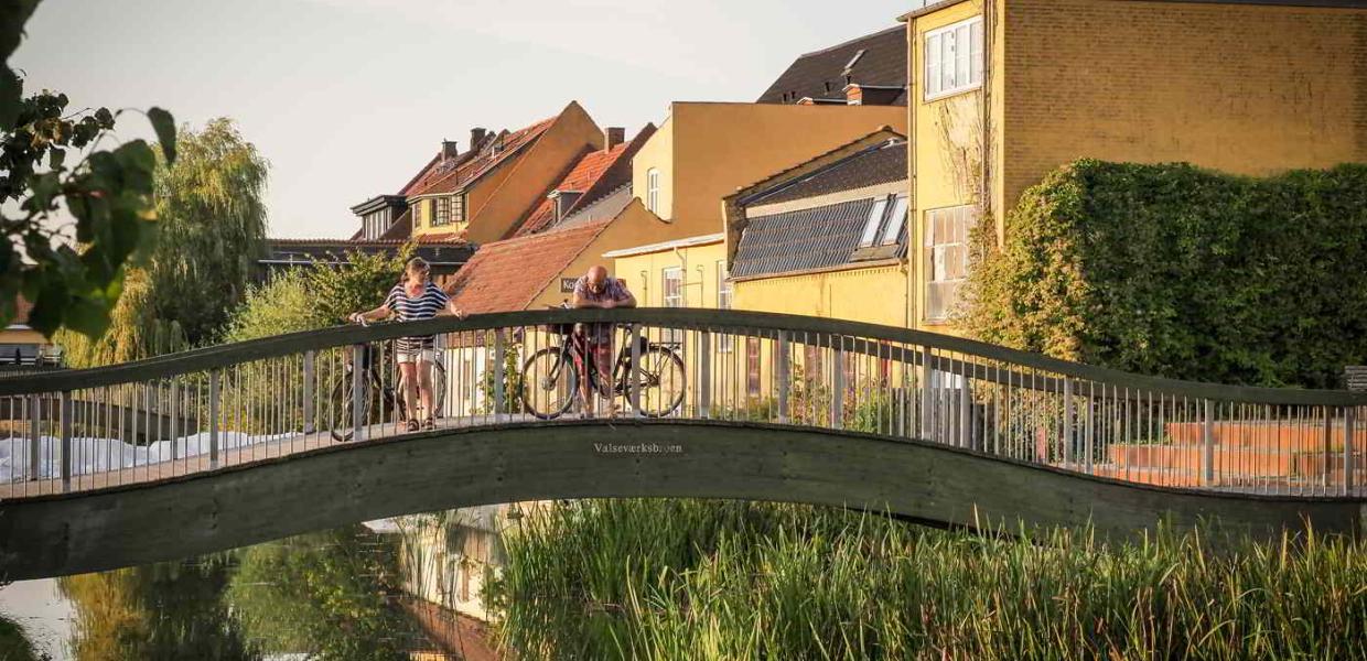 To cyklister holder en pause på en af broerne over kanalen i Frederiksværk.